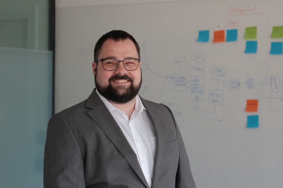 Dr. Marco Häuser vor einem Whiteboard mit Schaltungsskizze