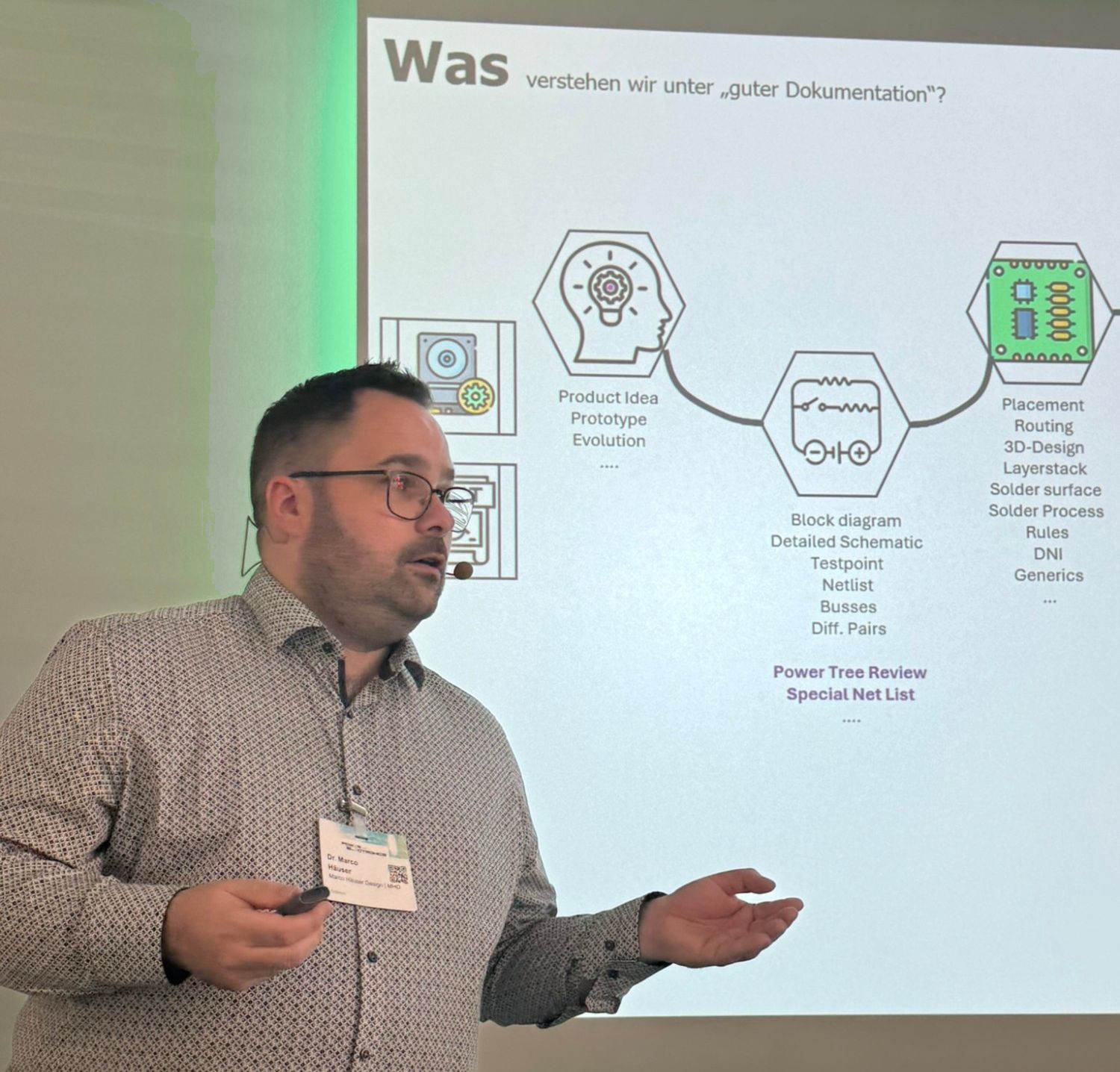Dr Marco Häuser in profile, pointing at the projected slide with the question "What do we mean by good documentation?" and the first links of the process chain: Product Idea, Block diagram, Placement